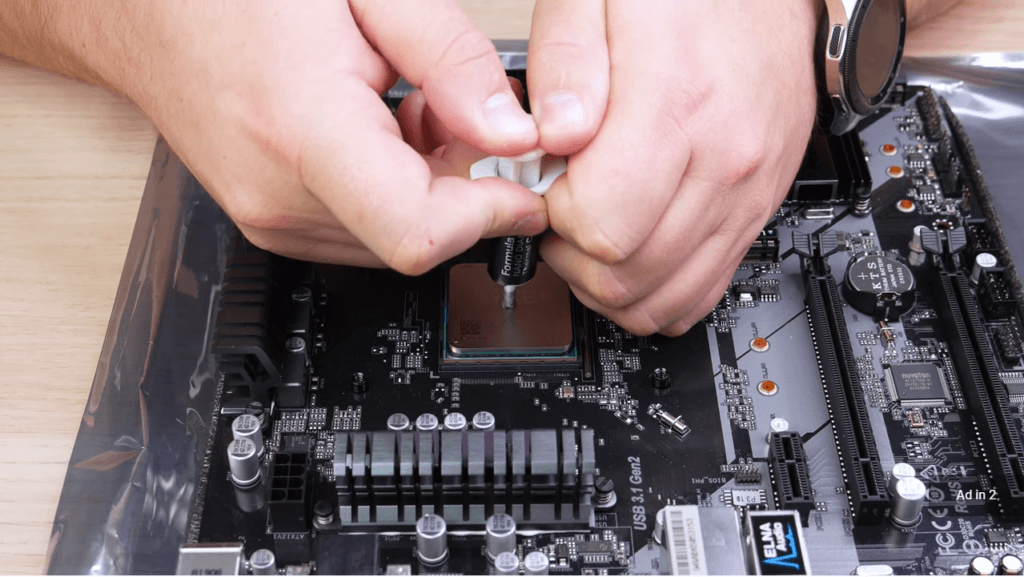 A technician putting CPU cooler compound on the CPU