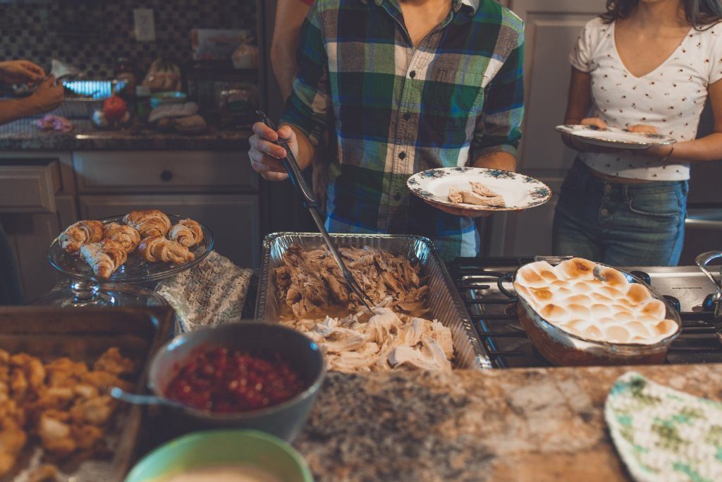 A picture of a holiday dinner spread with two people serving food. 