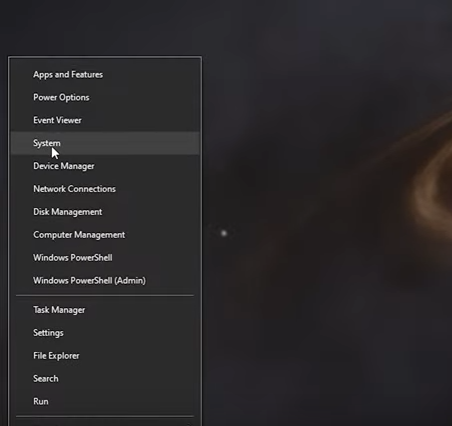 A screenshot of Windows in dark mode and opening the start menu with the mouse clicking on "System".